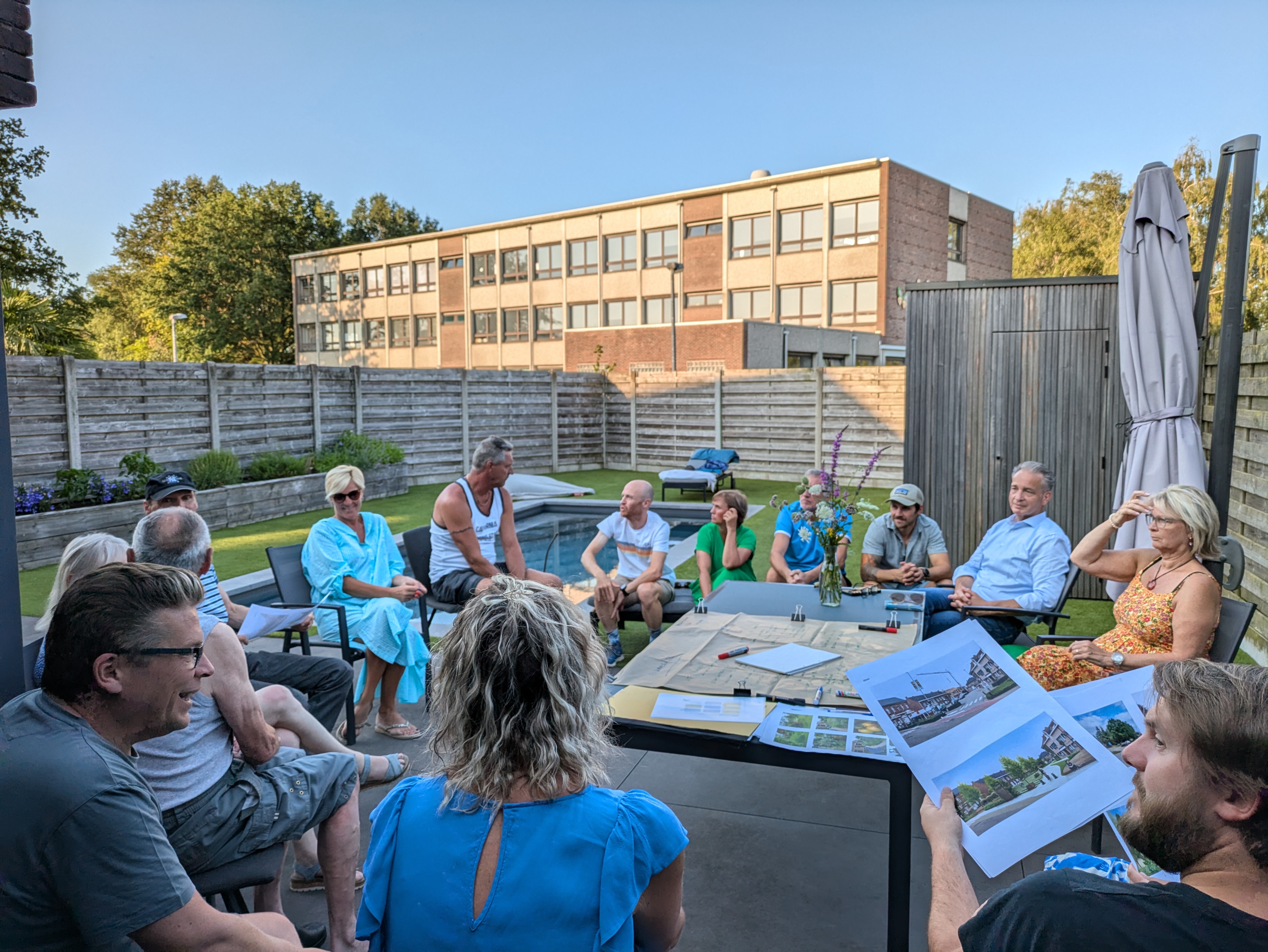 mensen rond tafel bekijken foto's en plannen
