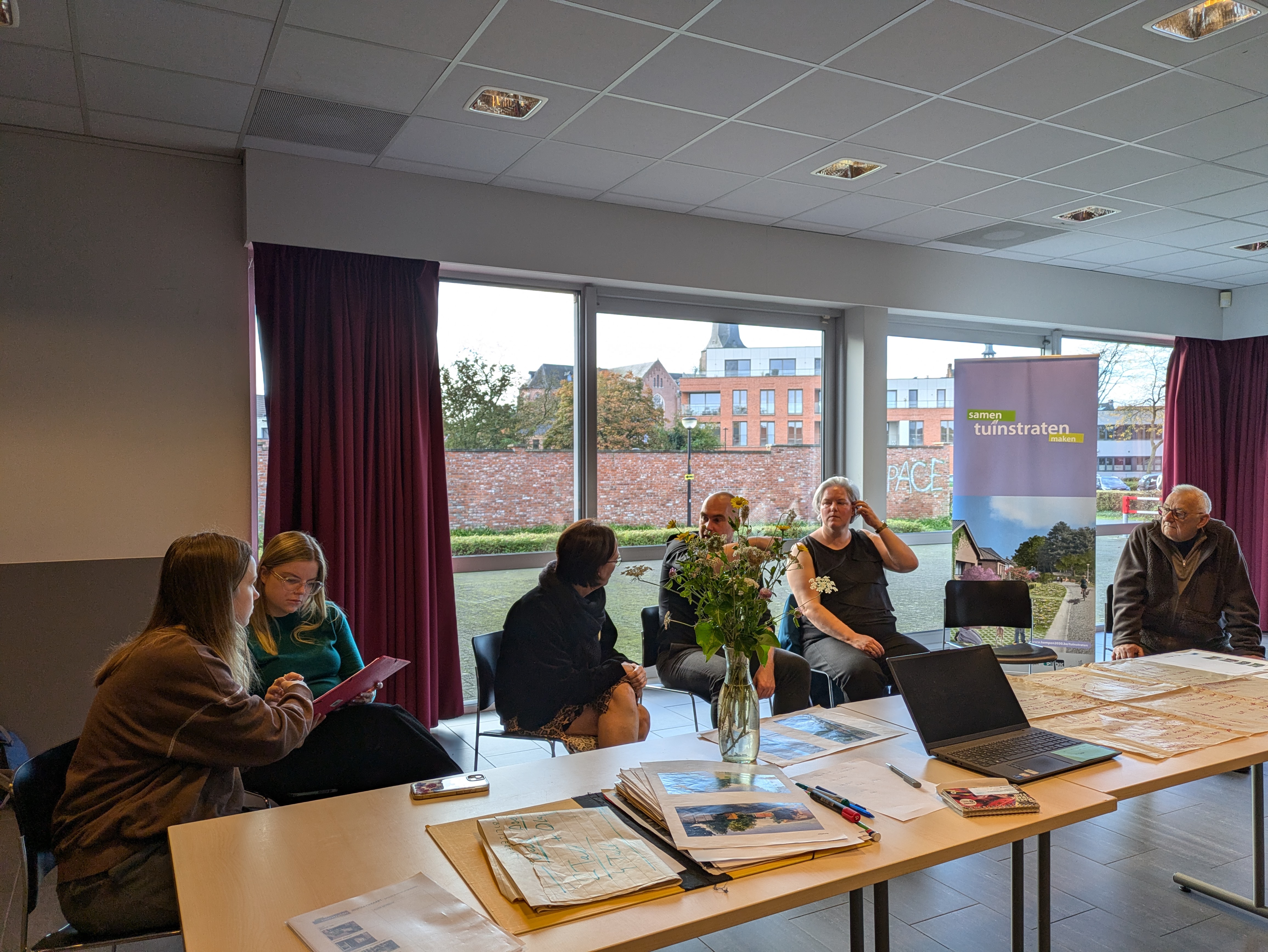 mensen rond een tafel + banner van tuinstraten