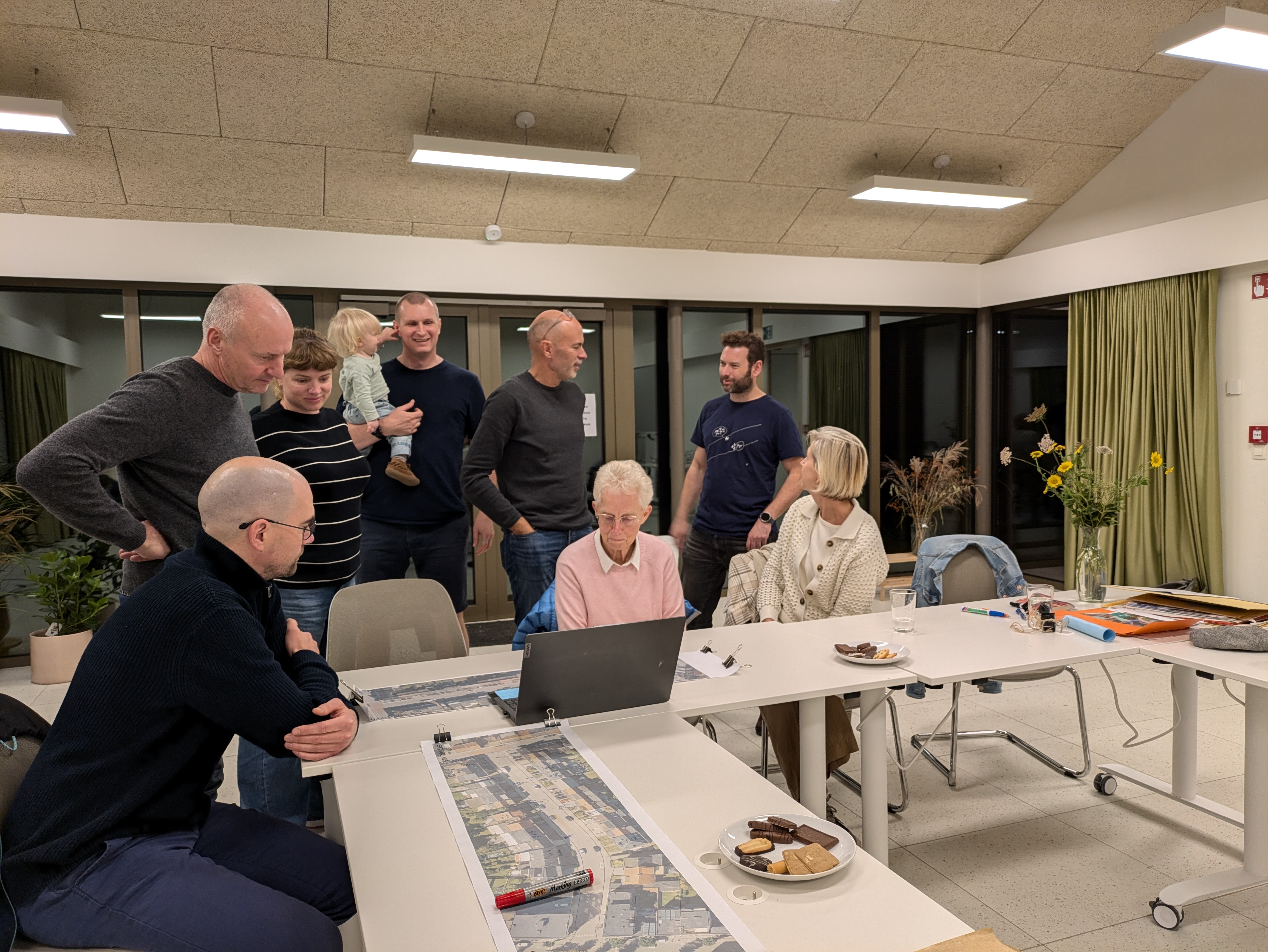 Mensen rond tafel kijken naar plannen straat
