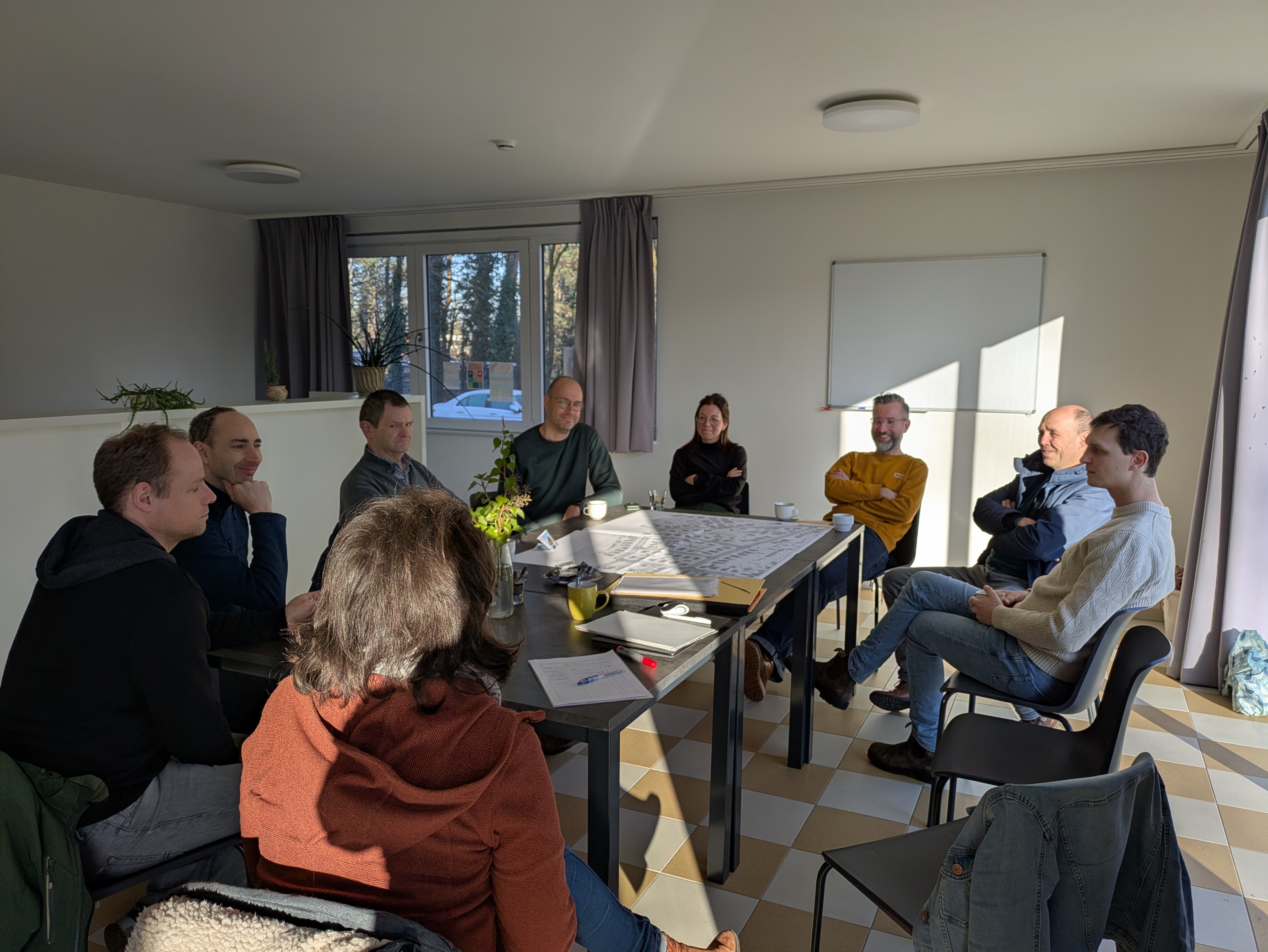Mensen rond een tafel met plannen van hun straat