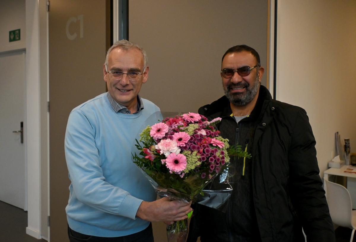 Loketmedewerker Rik geeft bloemen aan de 10.000ste bezoeker
