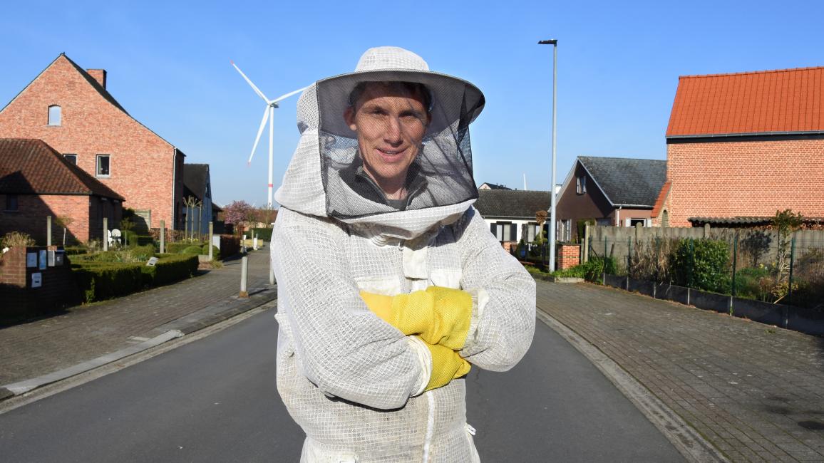 Imker staat in een grijze straat