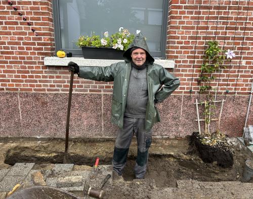 Man leunt op schup in pas aangelegde geveltuin