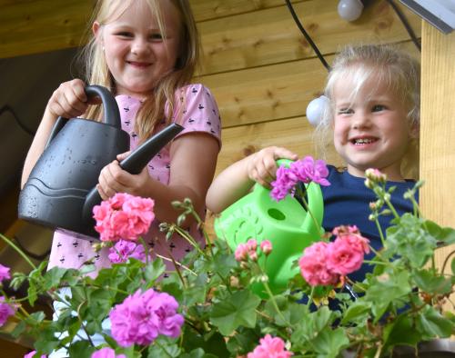 Kinderen geven bloemen water