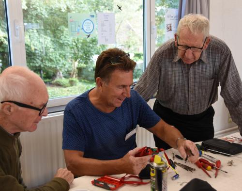 Man helpt bij het repareren van kapotte spullen